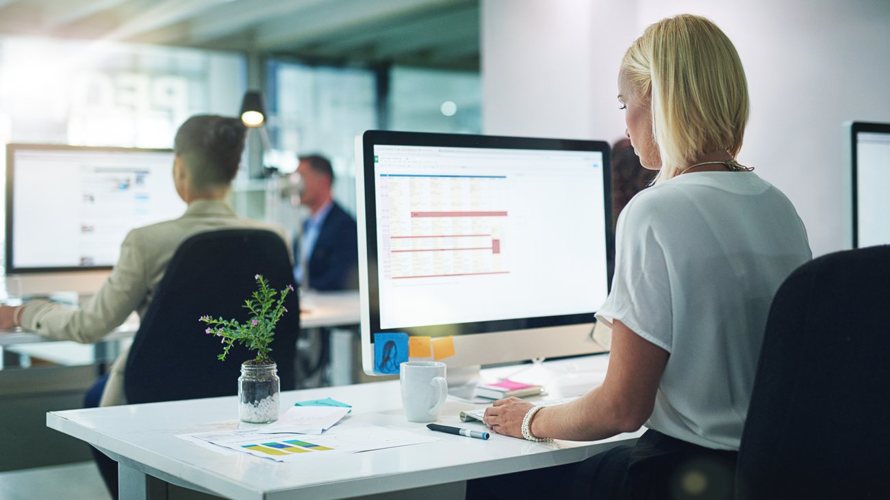 Generische Officeszene: Frau sitzt vor Bildschirm